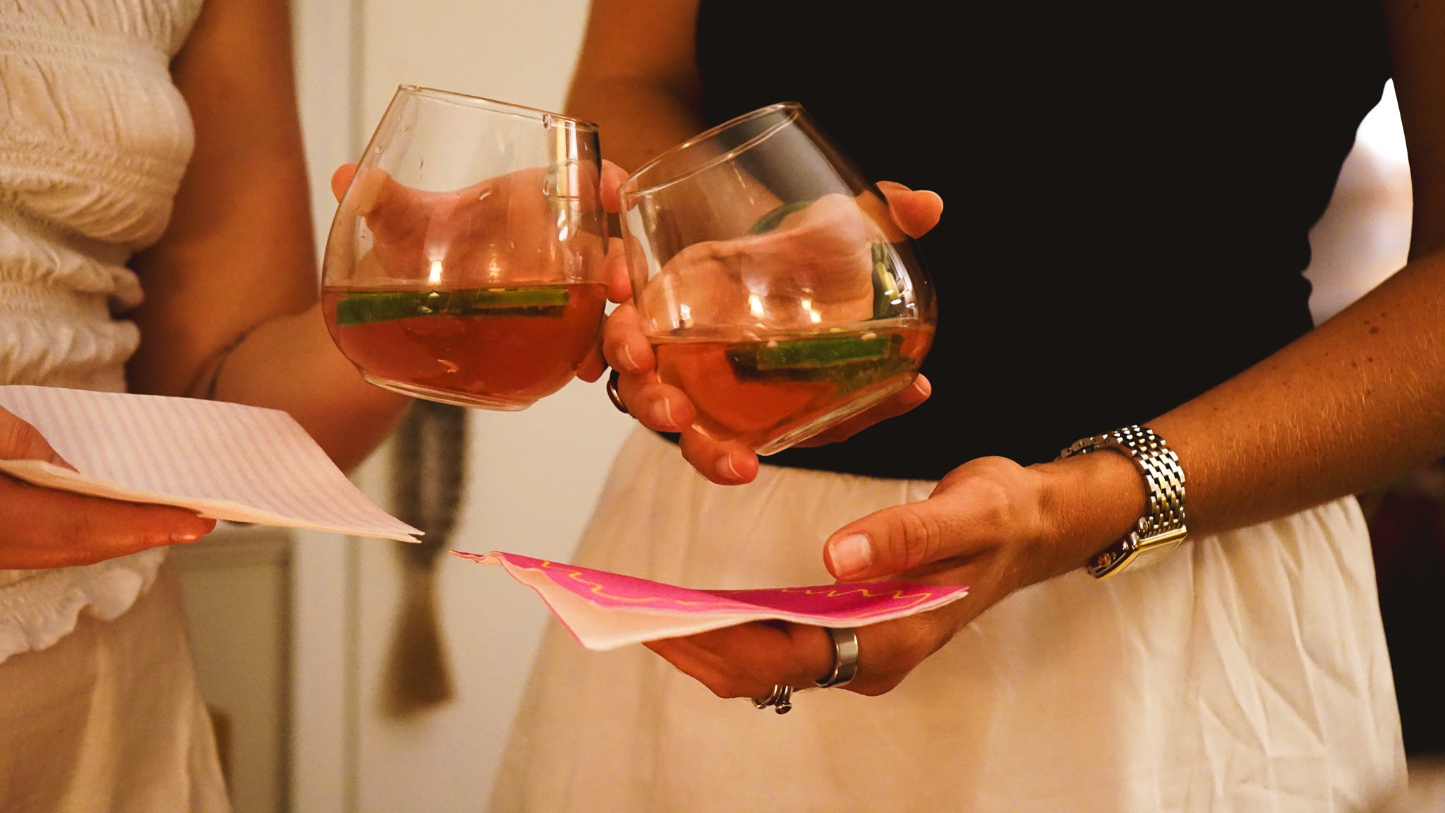 Two people holding glasses of rose with a blurred background