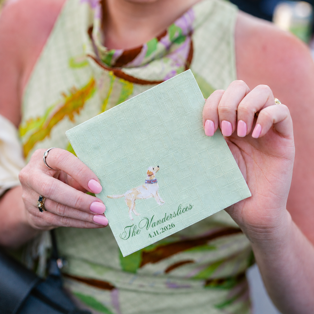 Woman holding a green napkin with a dog design and text at a wedding